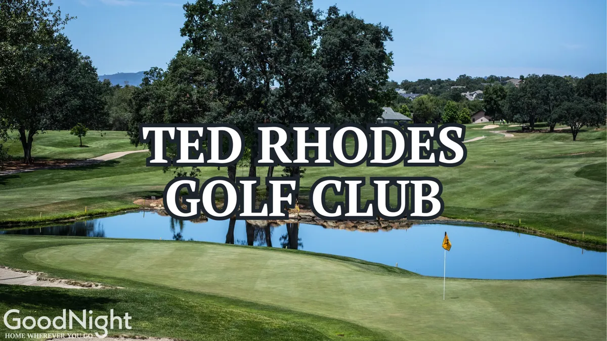 A sweeping view of a lush golf course with a water hazard and a flag planted on the green. Mature trees line the fairways and the tranquil water reflects the sky, creating a peaceful, outdoor ambiance. Golfers can be seen enjoying a round, emphasizing the leisure and camaraderie of the sport.