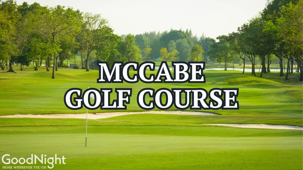 A view across a manicured golf course with vibrant green fairways, mature trees, and a golf flag marking a hole. The tranquil setting invites both golfers and nature lovers alike for leisurely rounds or serene strolls.