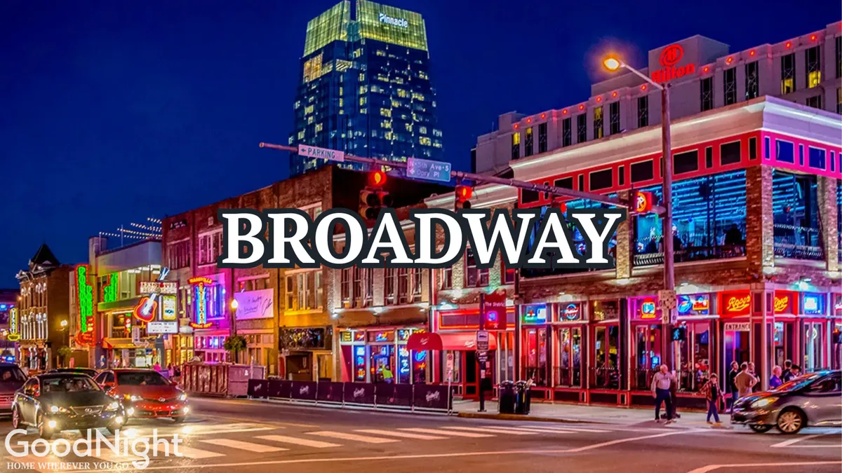 A bustling nighttime street scene featuring neon signs, high-rise buildings, busy sidewalks, and people enjoying Nashville's dynamic entertainment district. The image pulses with energy, showcasing the heart of the city's nightlife and live music culture.