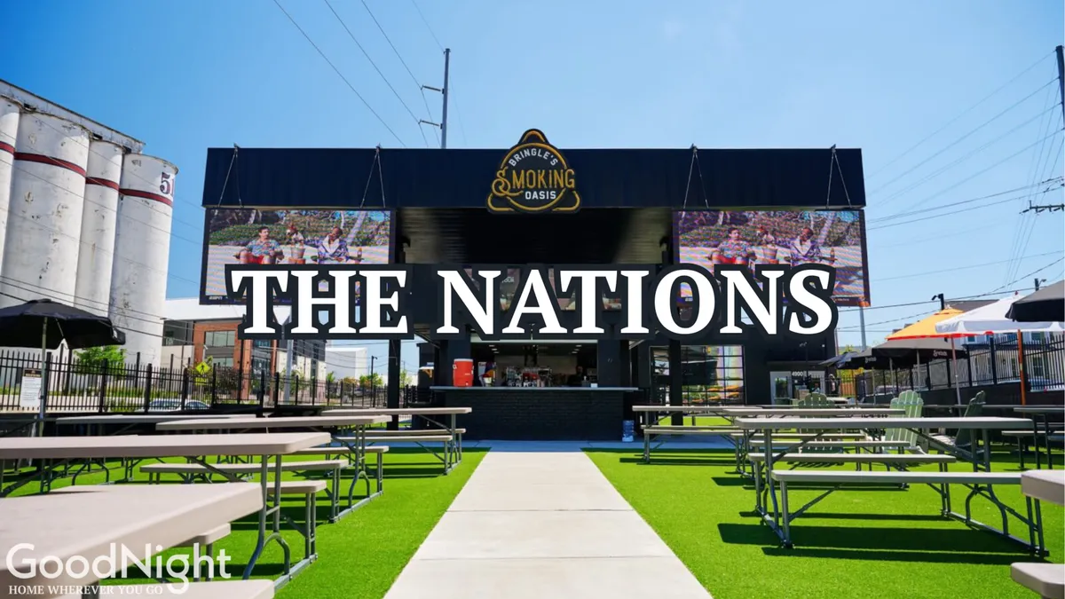 An energetic exterior setting with large signage reading 'THE NATIONS', outdoor seating areas, and a barbecue grill setup. People gather for food-tasting events and live music, evoking a festive community spirit.